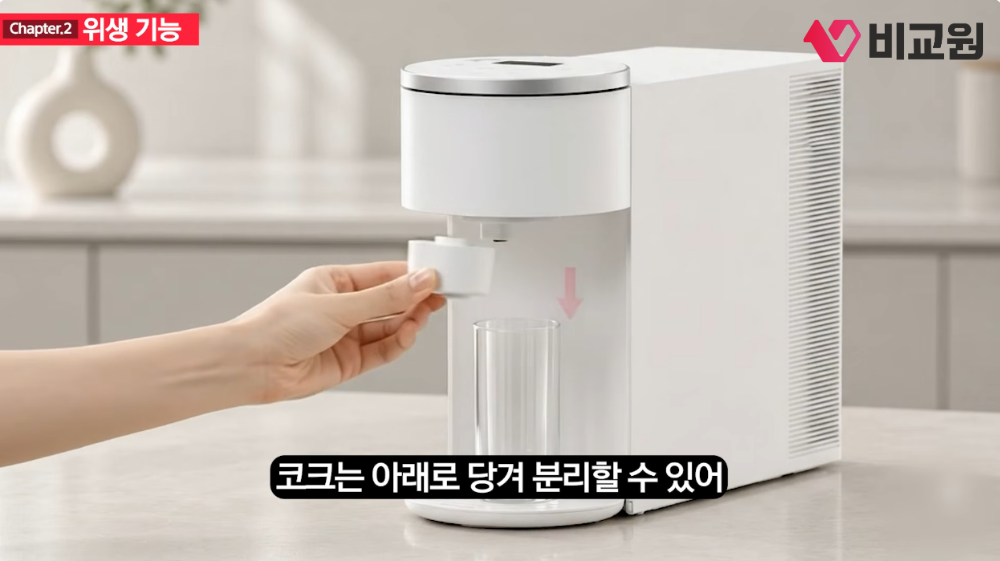 정수기 코크를 아래로 당겨 분리하는 장면