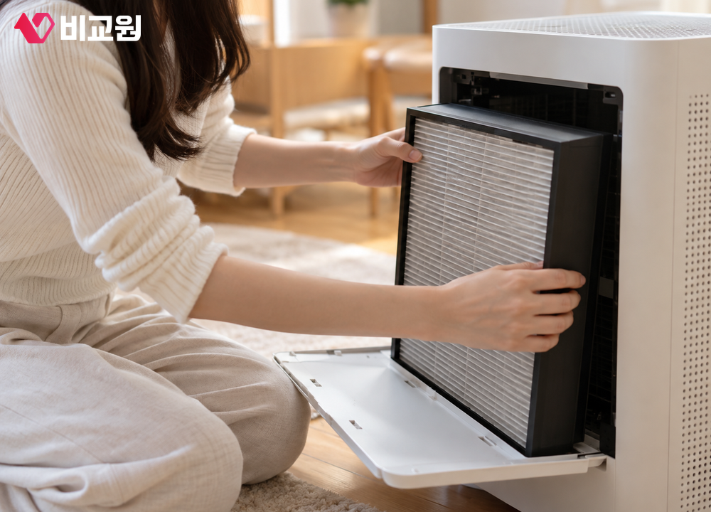 공기청정기 앞면을 열어 필터를 꺼내 보는 모습