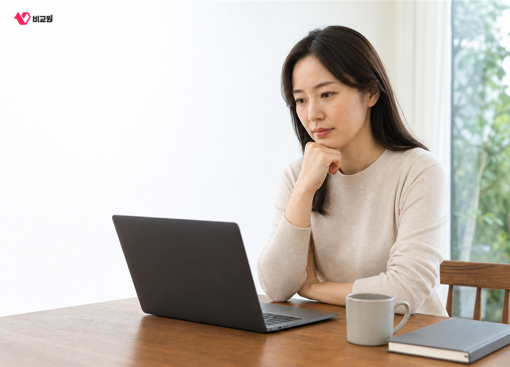 식탁에서 노트북을 보며 인터넷 상품 조건을 따져보는 모습