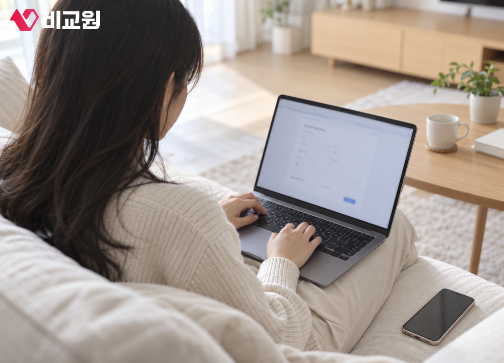 집 소파에 앉아 노트북으로 교통카드 번호를 등록하는 모습